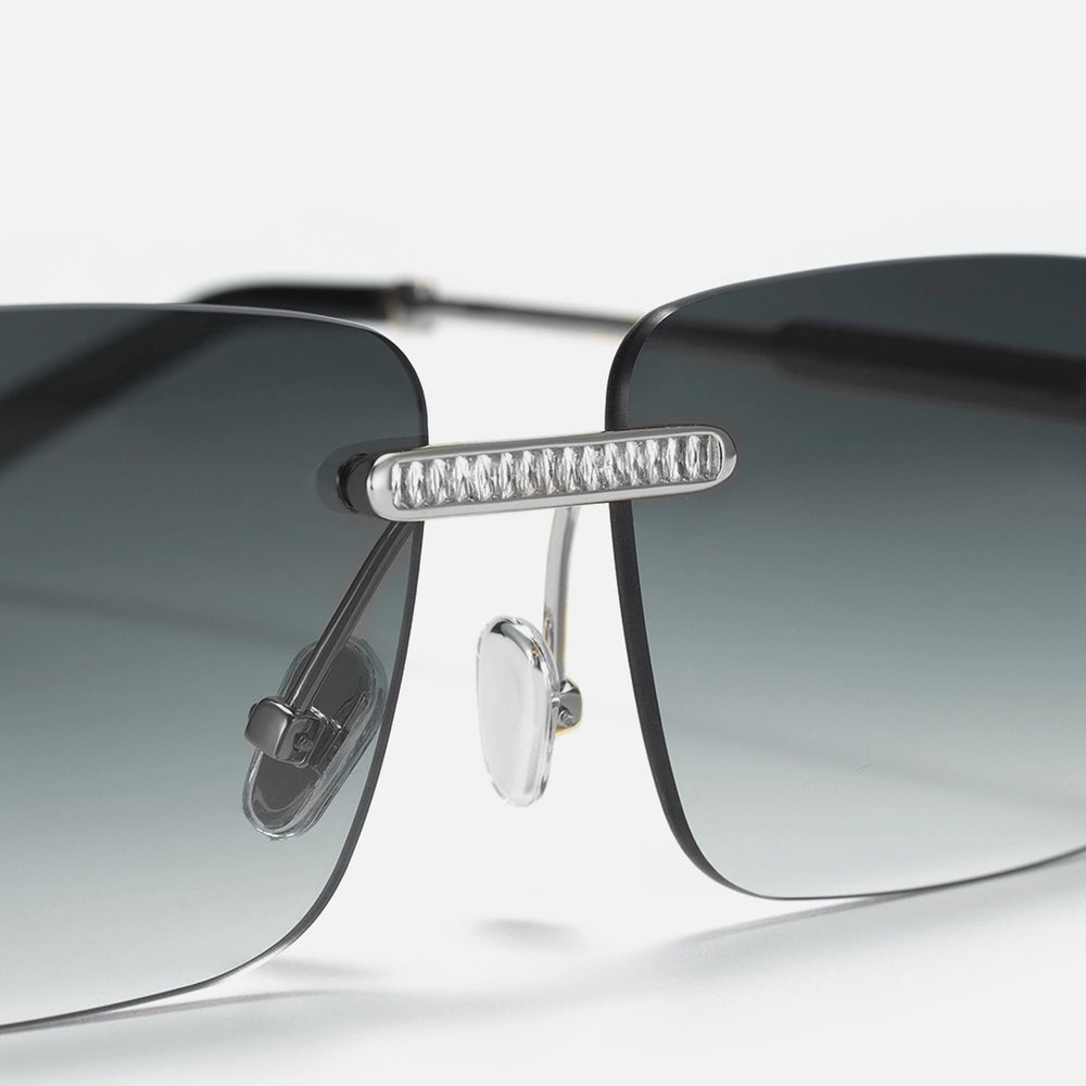 Sunglasses with gradient lenses and metallic frame on a light gray background