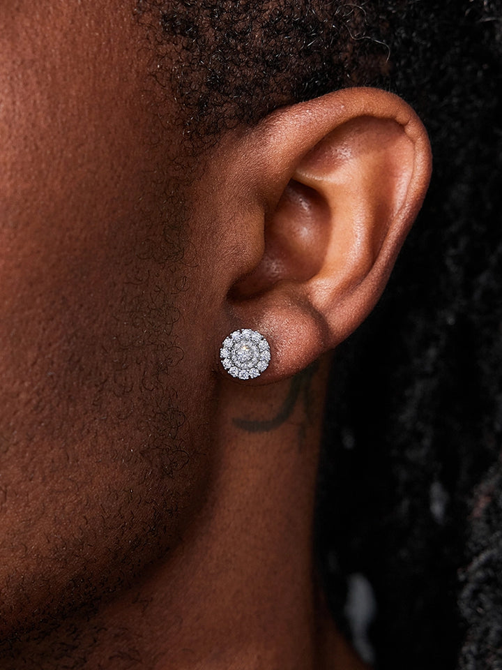 Close-up of an ear wearing a silver floral earring with a dark background